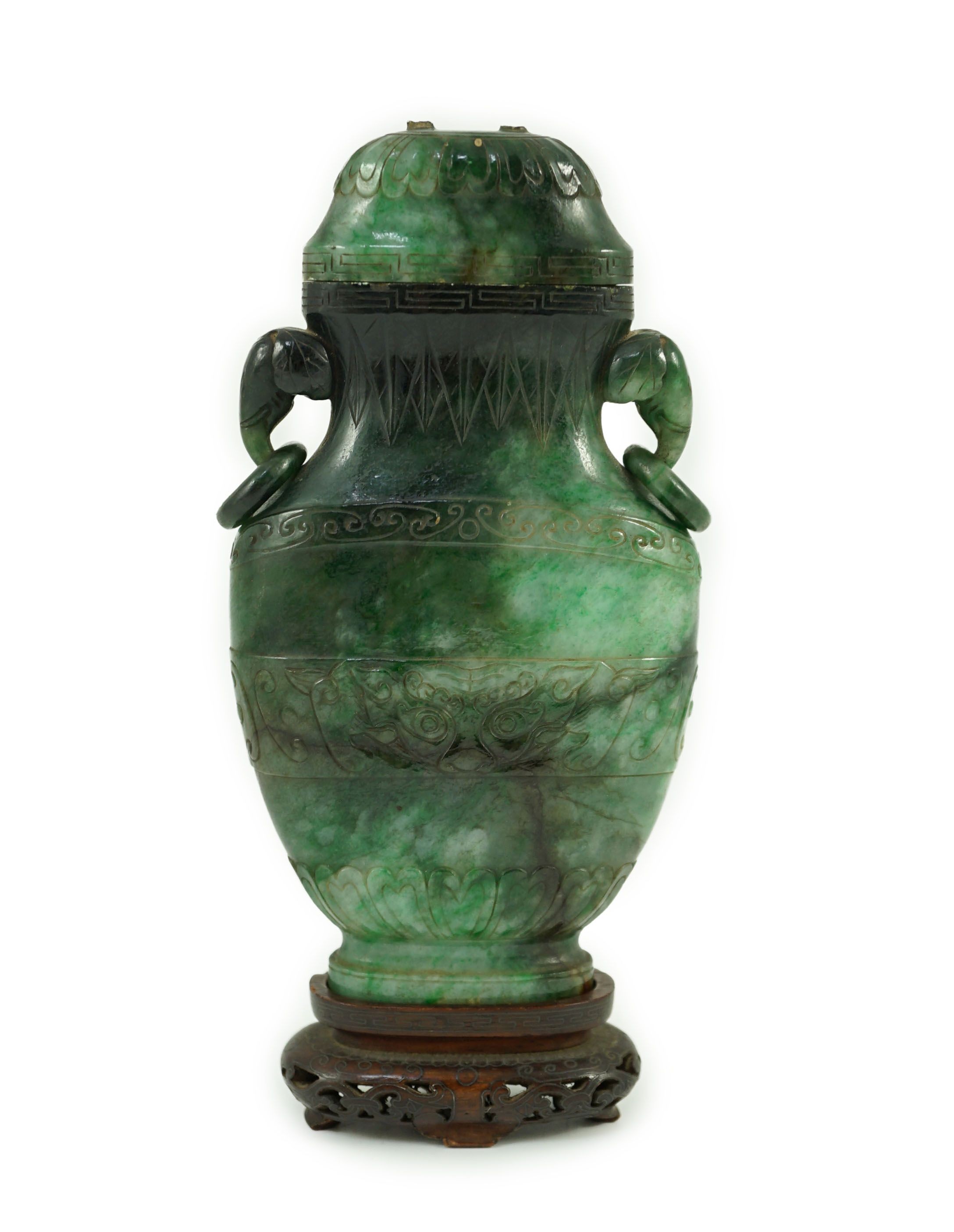 A Chinese archaistic green jadeite vase and cover, late Qing dynasty, 14.5 cm high, Silver wire inlaid wood stand, cover finial missing